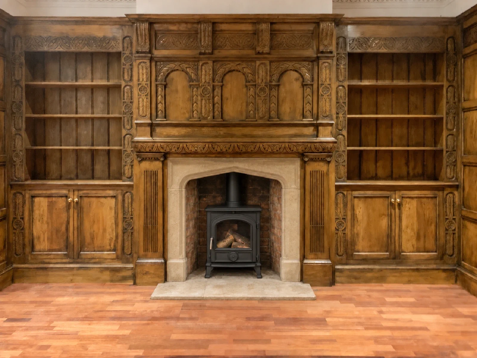 Carved oak overmantel with arcaded panels above a stone surround, flanked by carved bookcases and cupboards