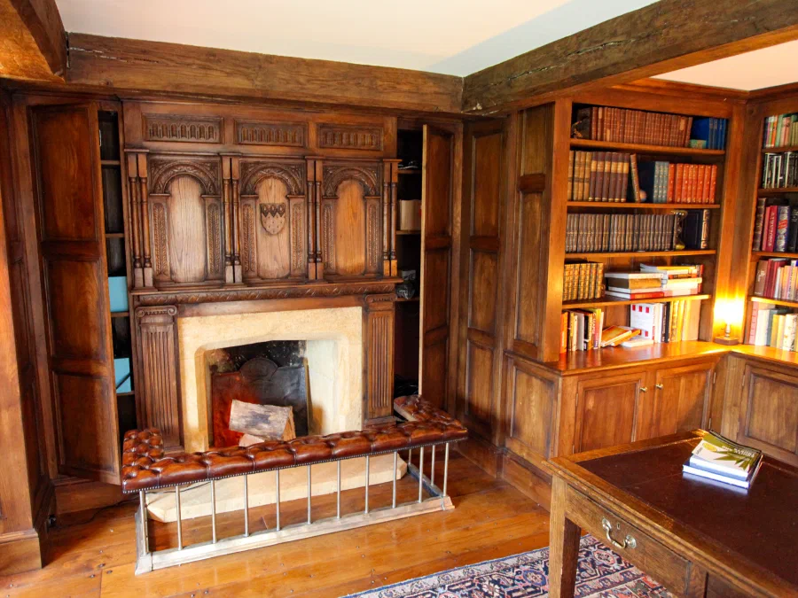 Carved overmantel framed by fitted library joinery