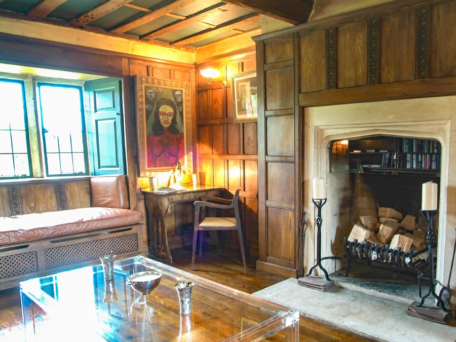 Stone fireplace opening framed by full-height timber panelling