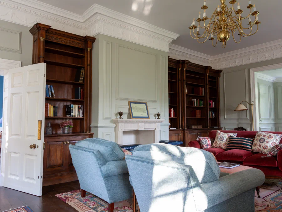 Painted drawing room at Alderwick House with full-height oak bookcases and wall panelling