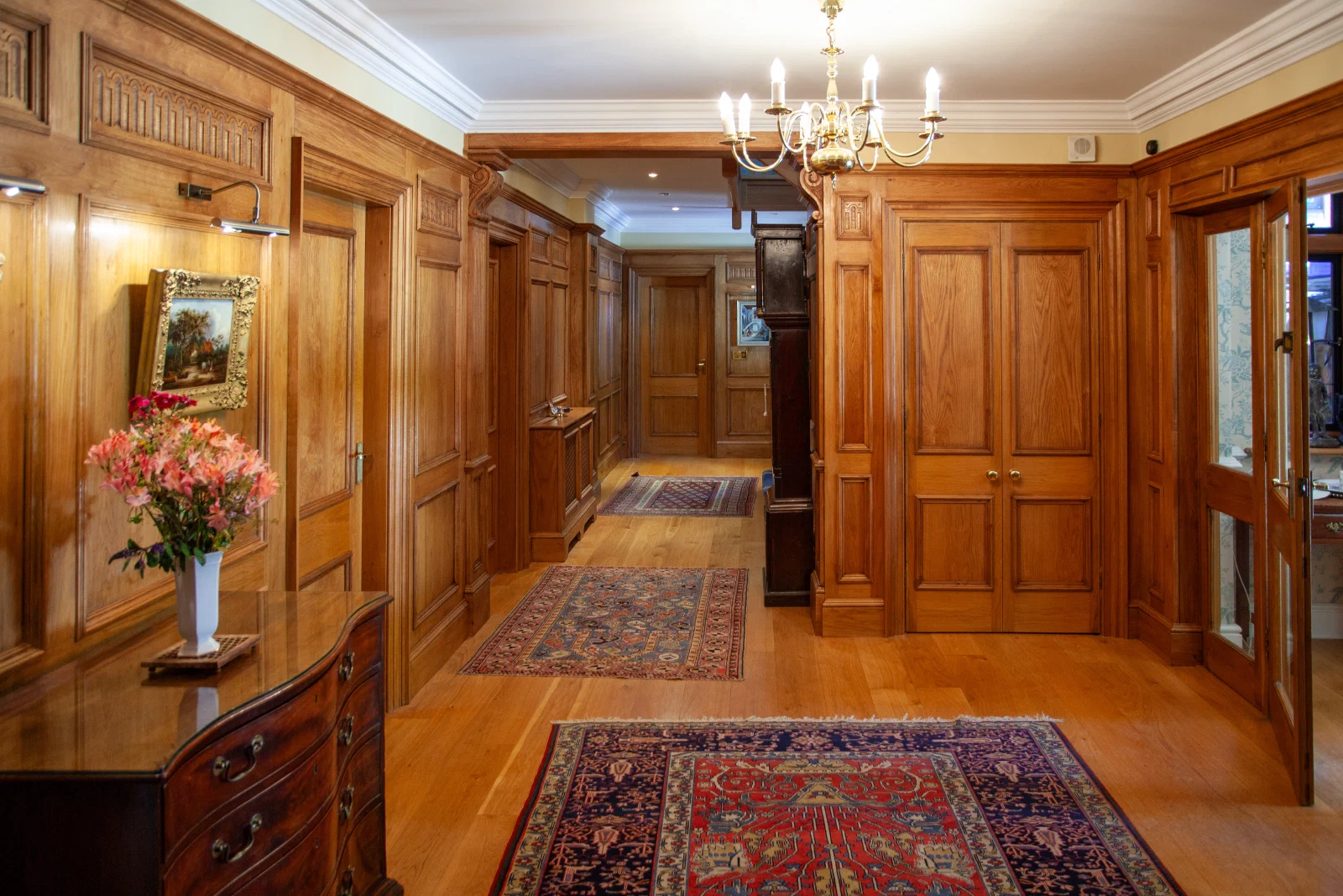 Oak panelled hallway with panelled doors carried through to adjoining rooms
