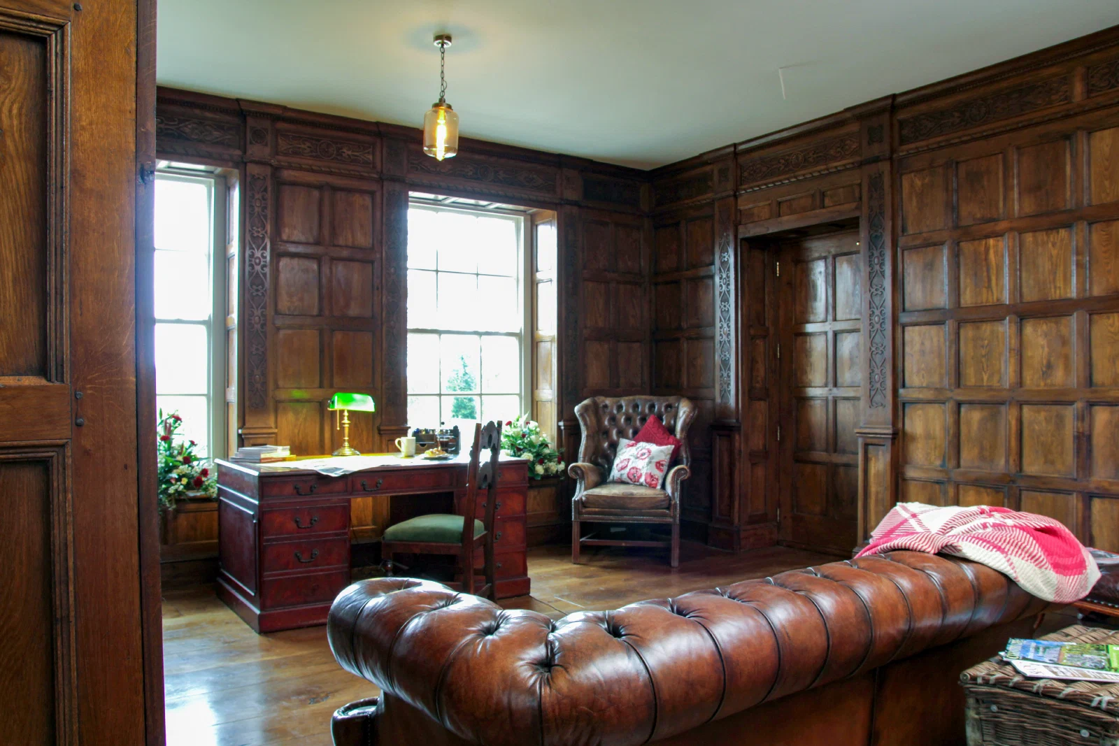 Oak panelled study with full-height panelling set out around the windows and doorway