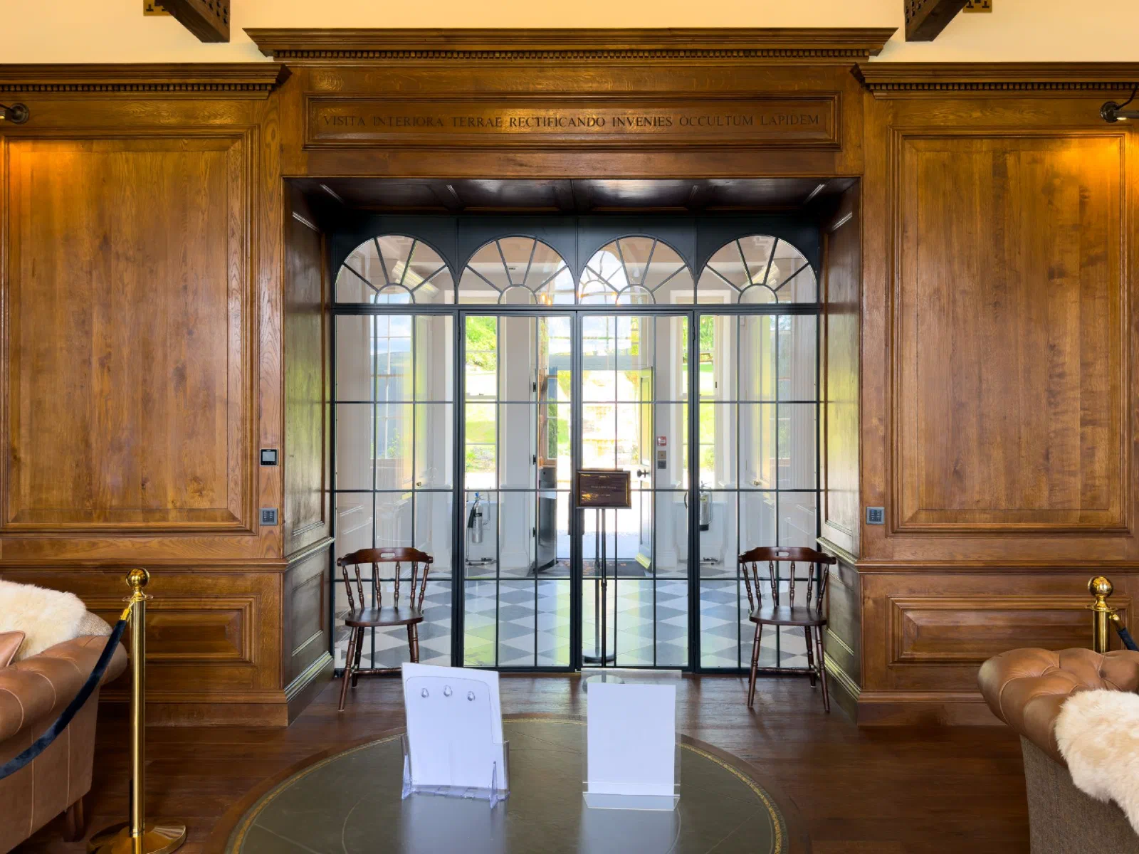 Oak panelled entrance at Boleskine House with a dentil cornice and lettered frieze above a glazed screen