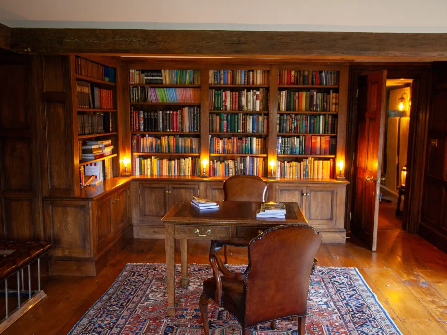 Fitted oak bookcases with lower cupboards in a complete panelled library