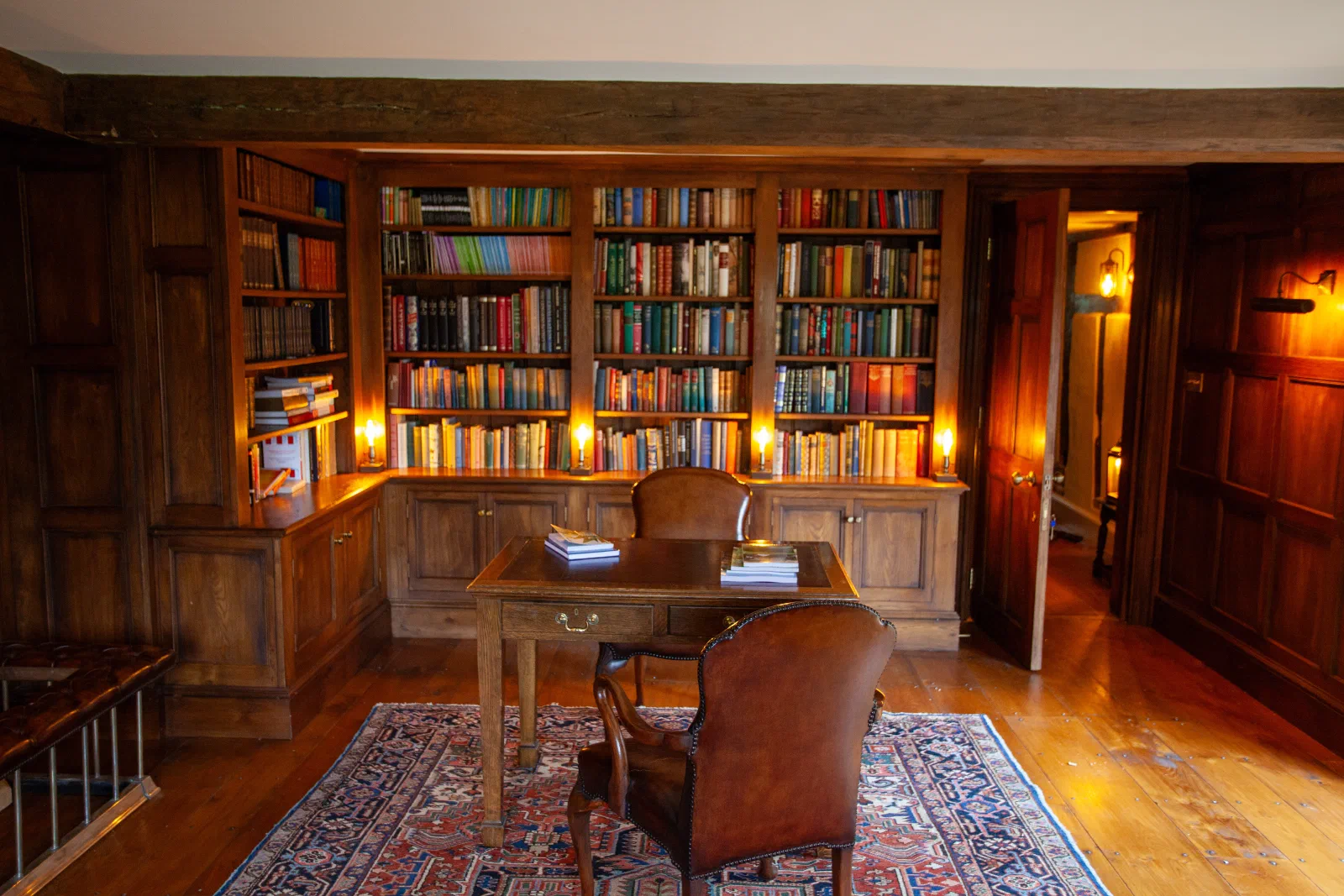 Fitted oak bookcases with lower cupboards in a complete panelled library
