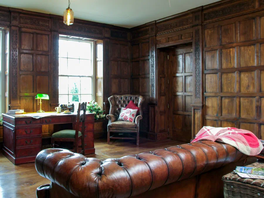 Full-height oak panelling arranged around two windows and an internal door in a study