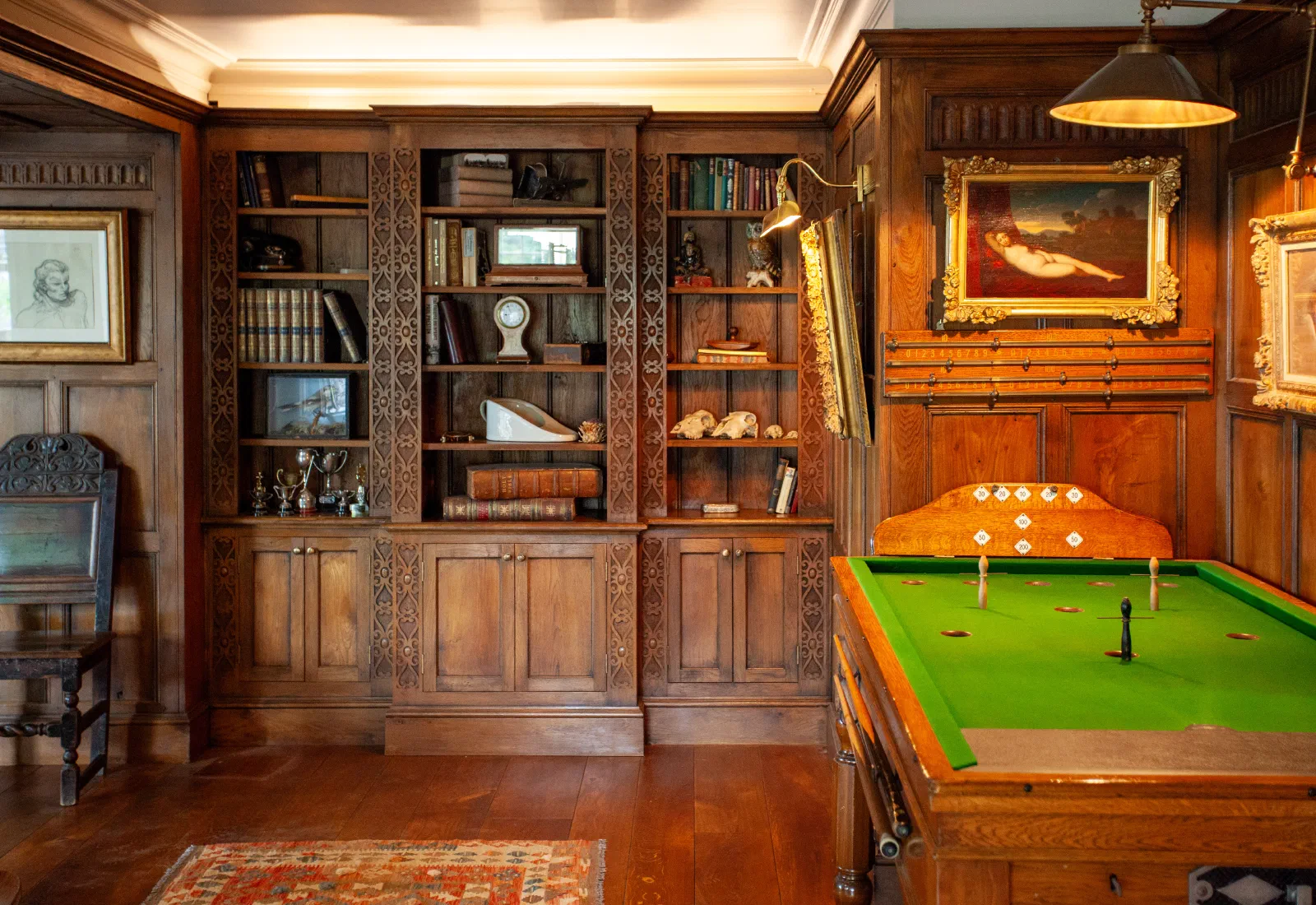 Fitted bookcases and lower cupboards within a richly panelled games room