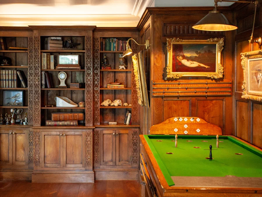Fitted bookcases within the panelled games room at River Yeo Lodge