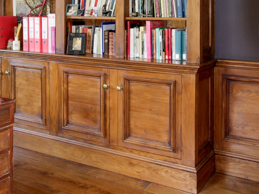 Fitted timber bookcase with lower cupboards in a panelled study