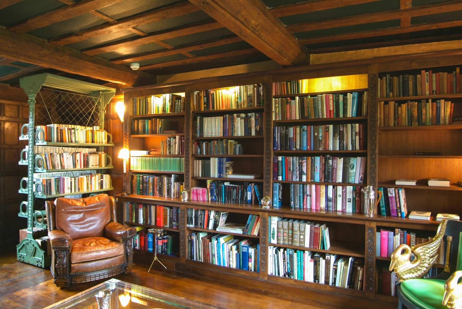 Long fitted bookcase run beneath the timbered ceiling of the library at the Grange