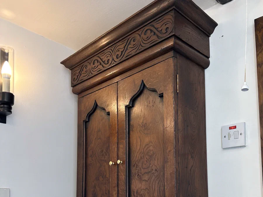 Timber wall cupboard above a towel rail in a bathroom