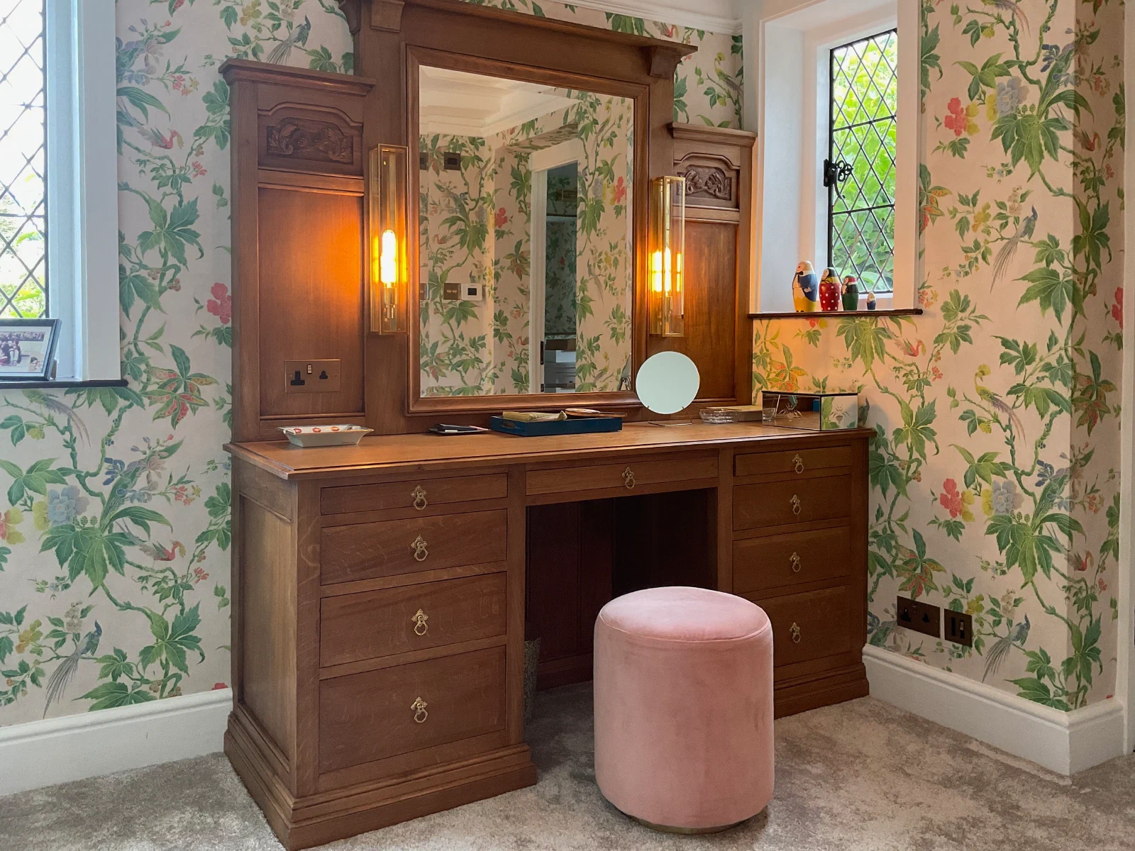 Timber dressing table fitted between windows with drawers and a framed mirror