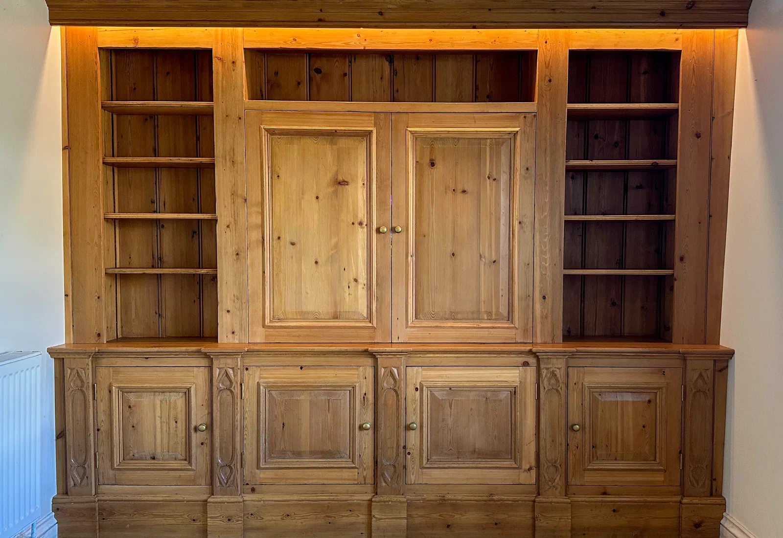 Fitted timber storage cabinet with shelves and panelled cupboards