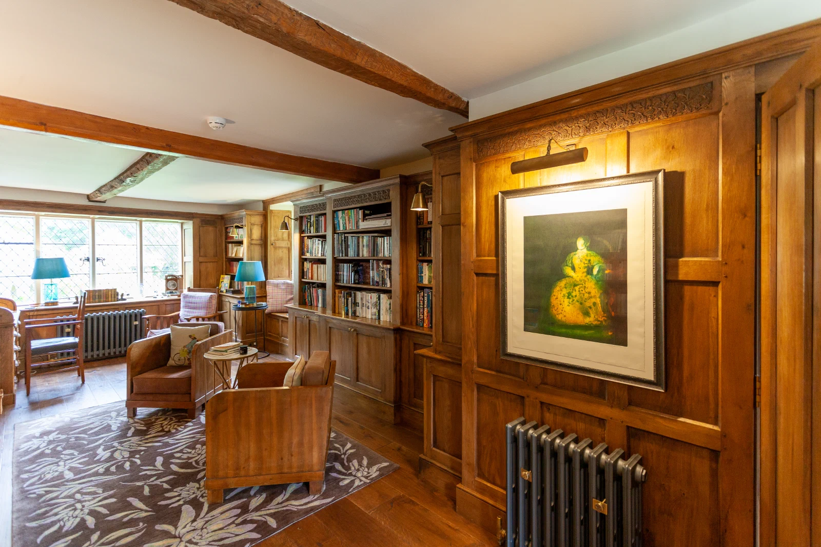 Oak bookcases and panelling forming a complete Arts & Crafts library interior