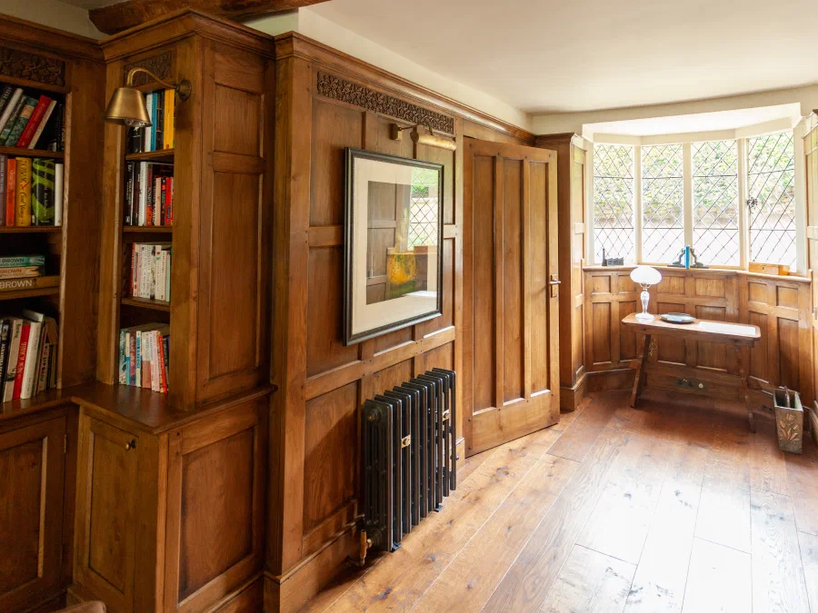 Oak-panelled library wall with framed artwork