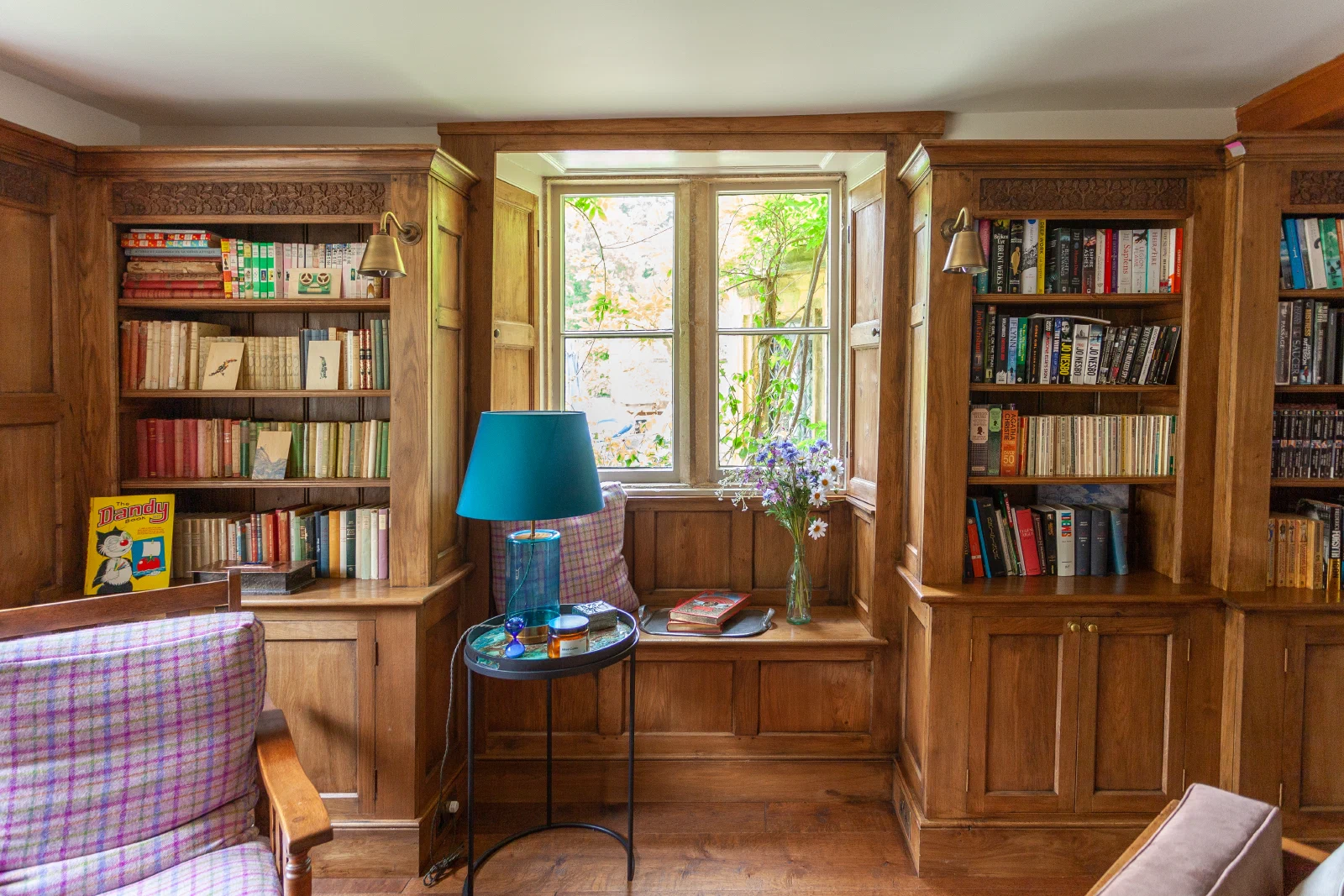 Fitted oak bookcases framing a window and window seat