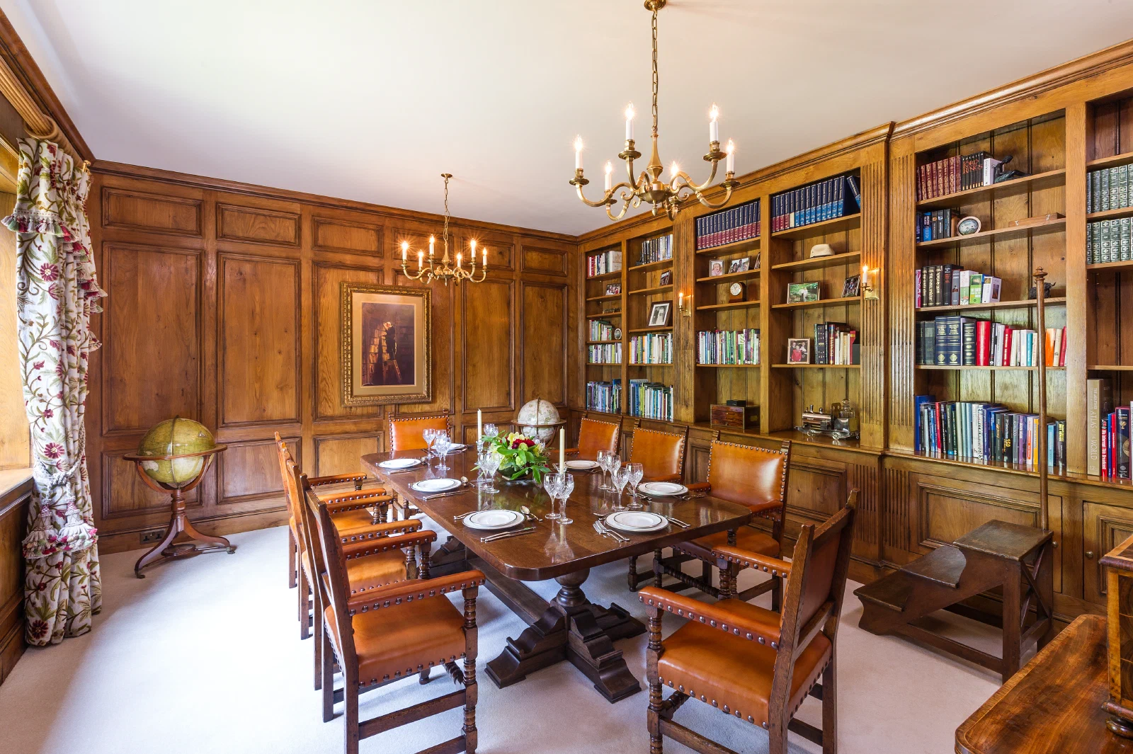 Oak panelled dining room with an extensive fitted bookcase and hand-carved pilasters
