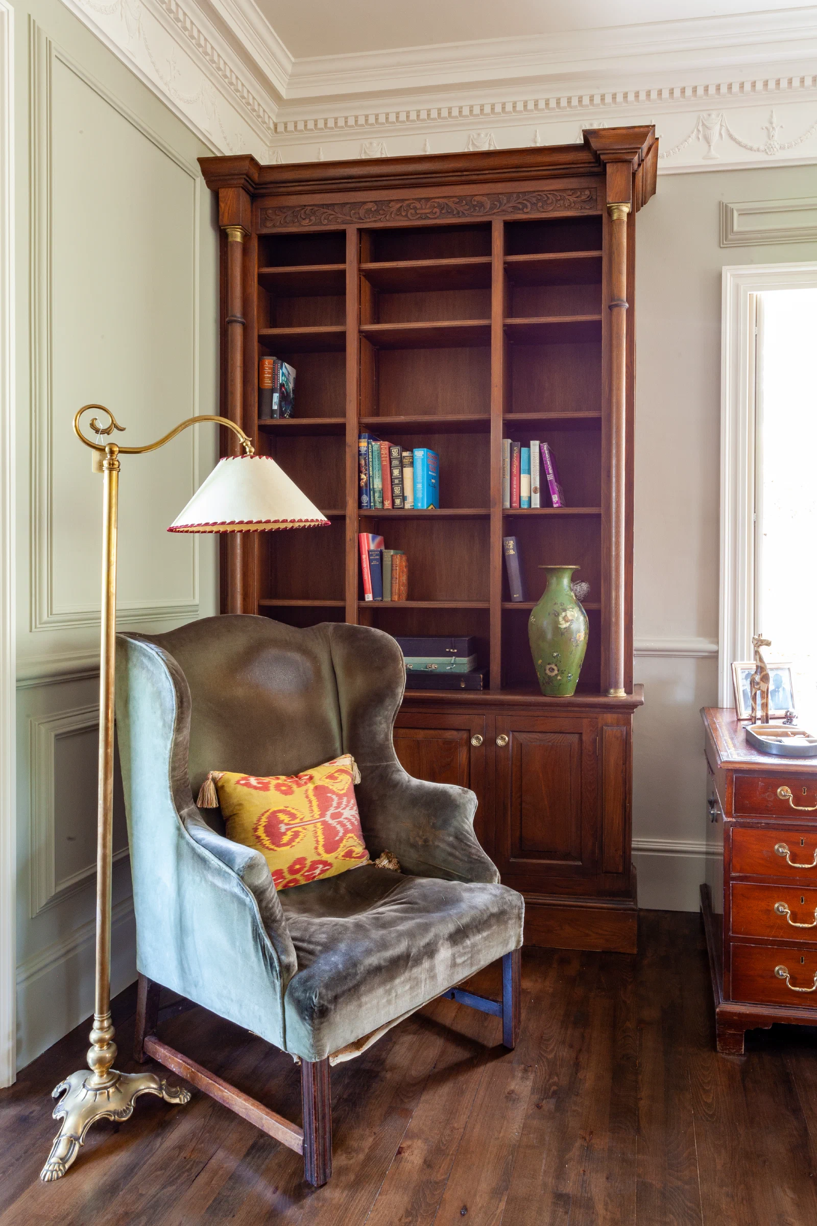 Carved oak bookcase set within Georgian wall panelling