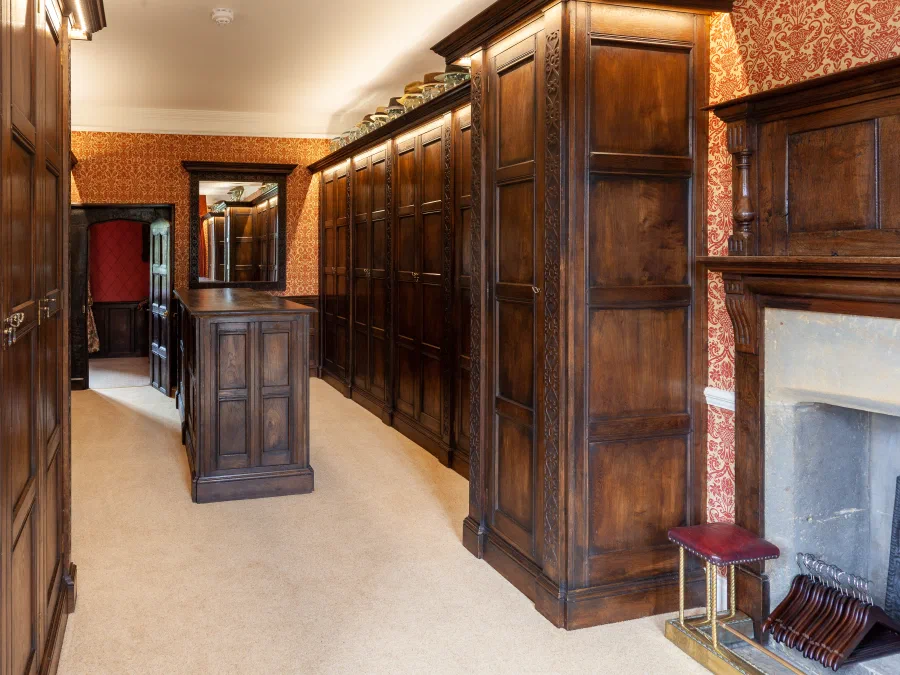 Fireplace and mirror frame between panelled wardrobes