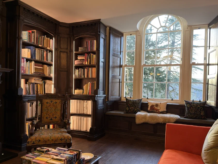 Arched library window framed by carved oak joinery