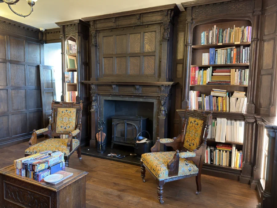 Dark oak fireplace and illuminated library shelving