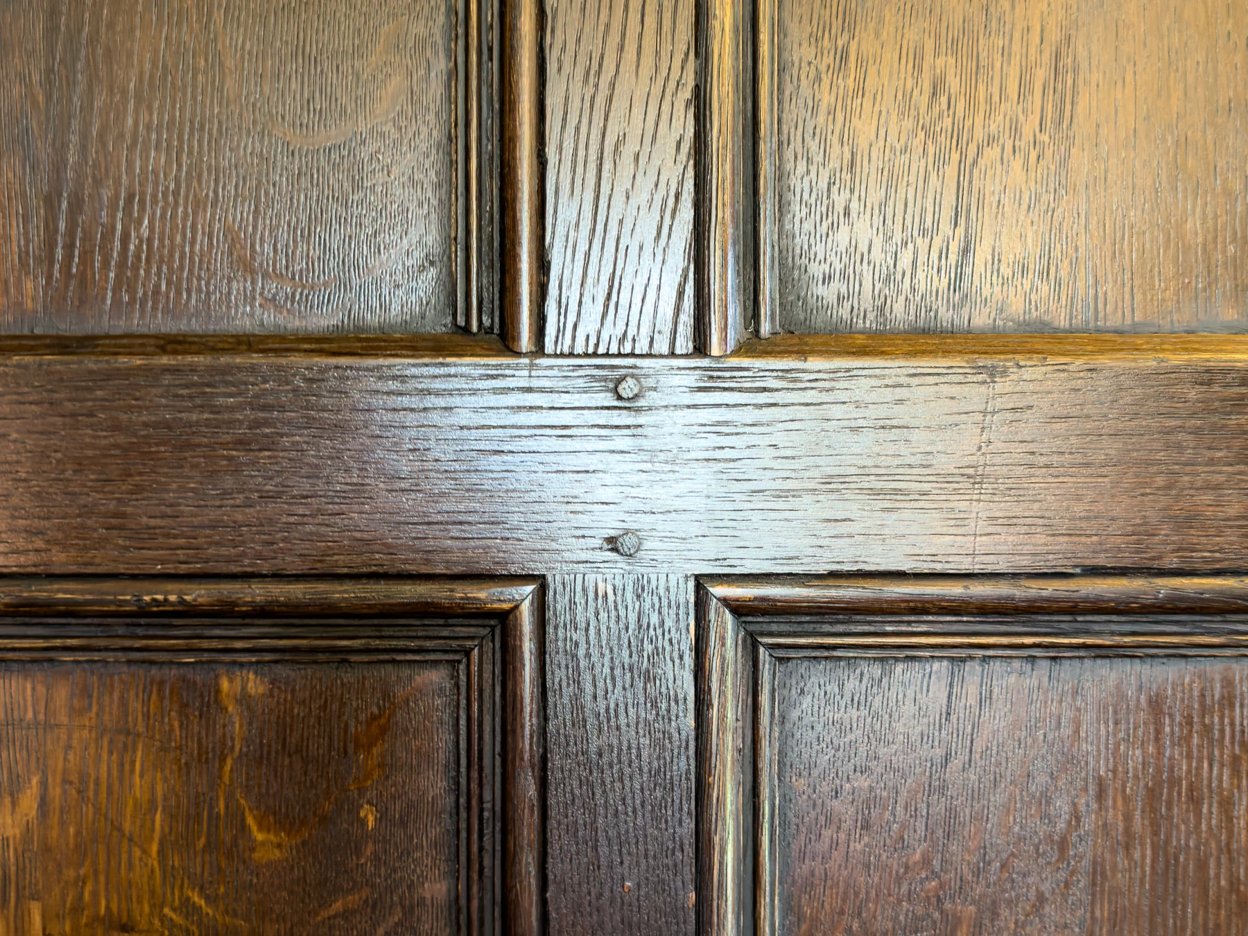 Oak grain showing through the dark finish on a panel