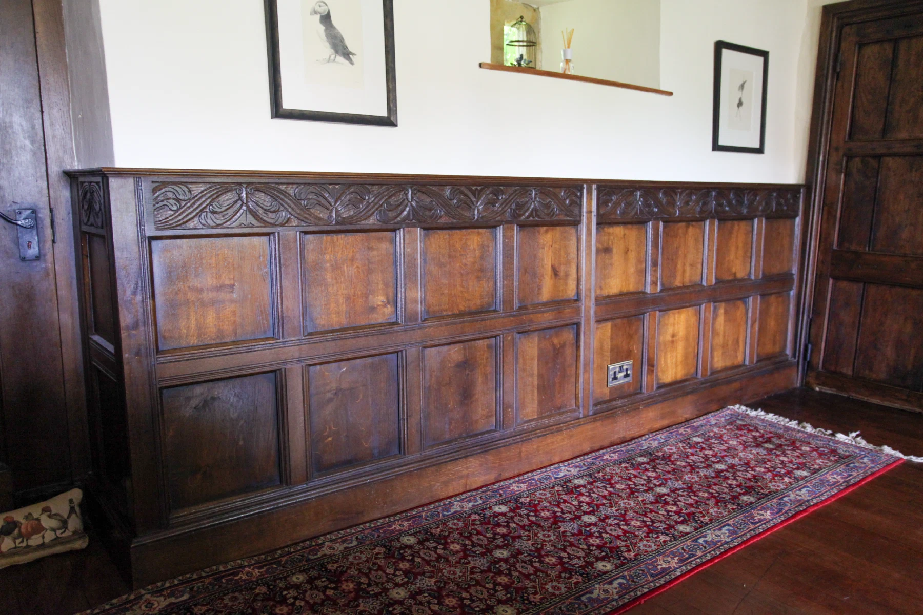 Oak dado panelling with a carved frieze rail along the landing wall