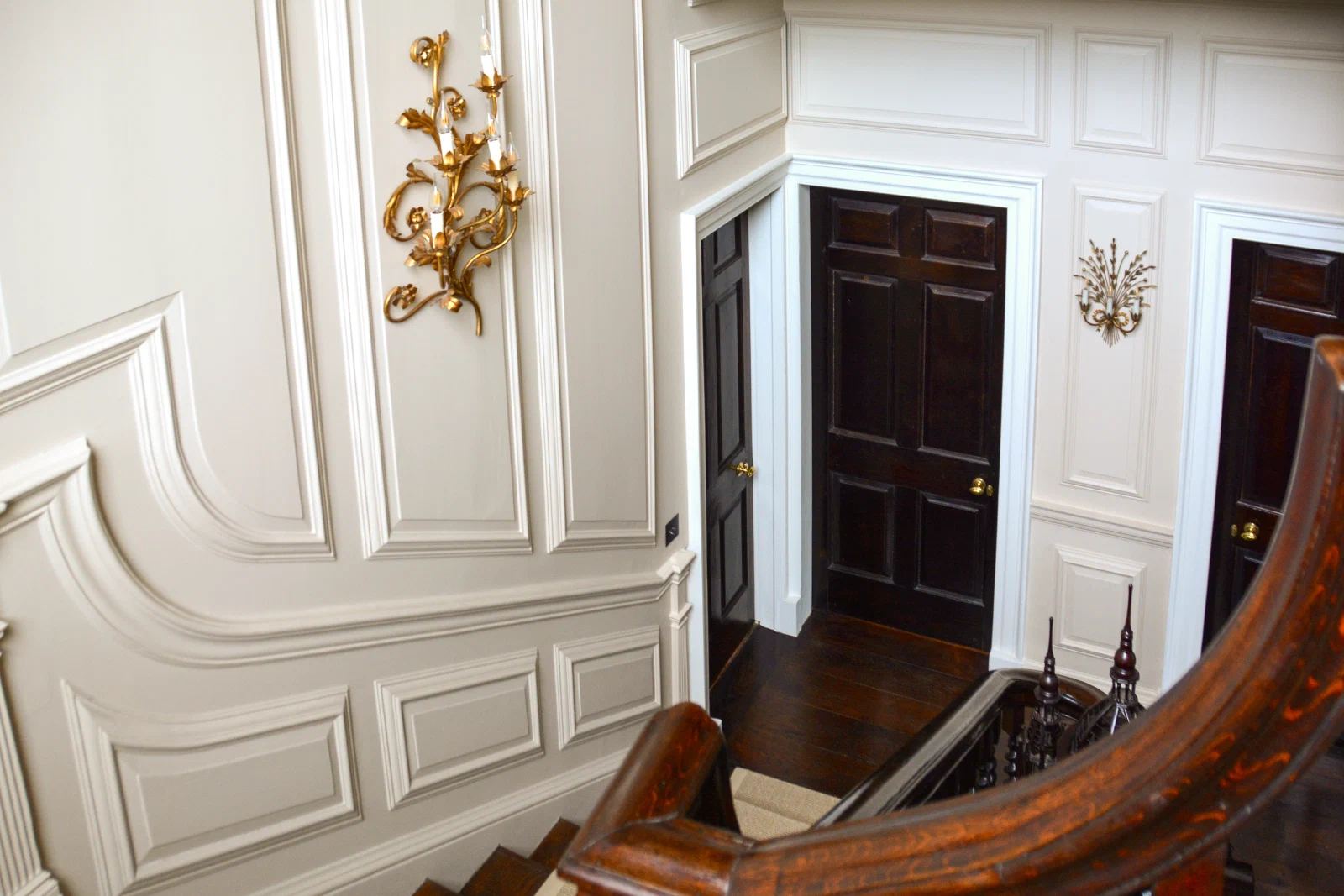 Shaped painted panels following the rise of the stair beside a doorway
