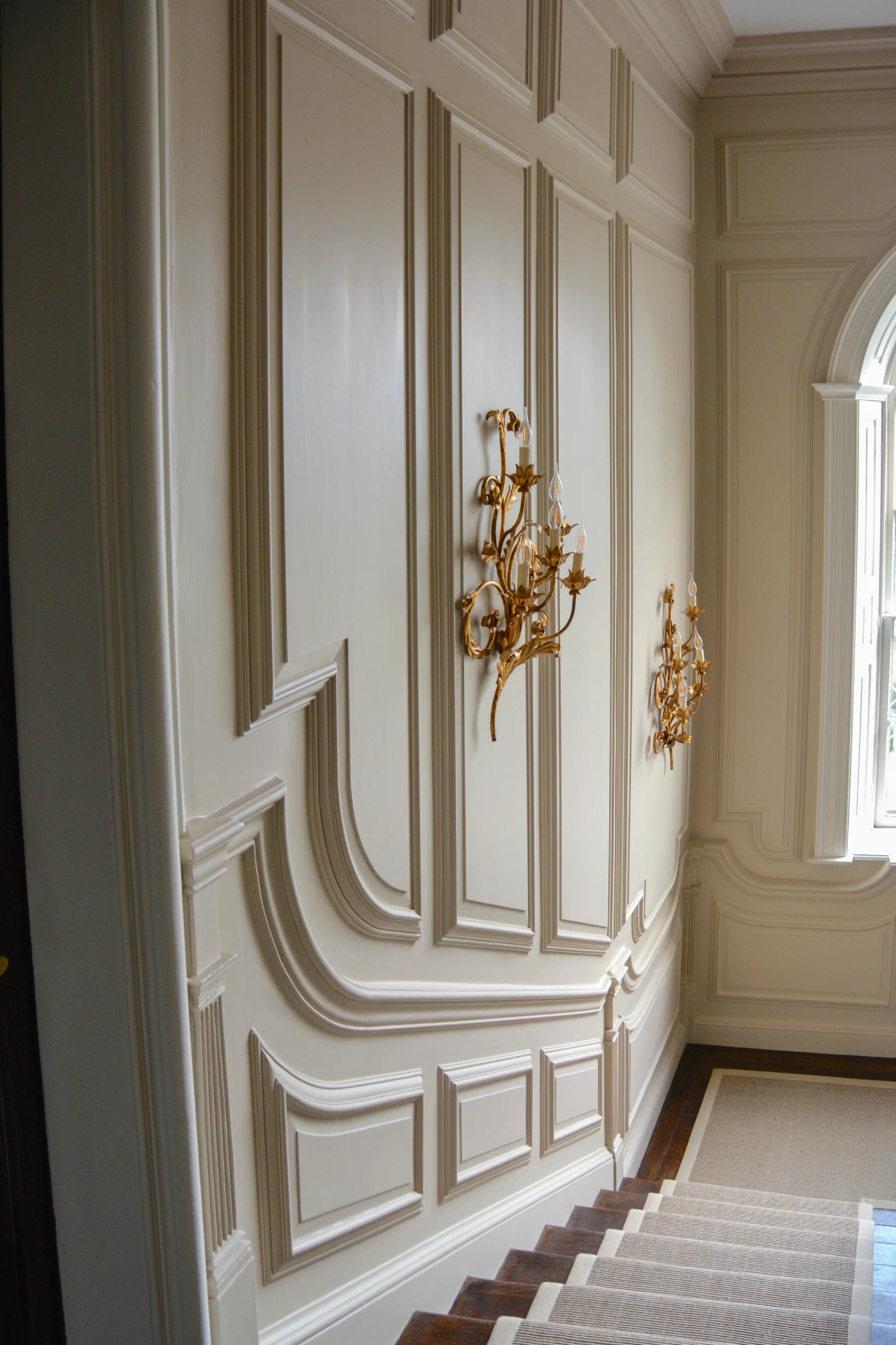 Tall staircase hall with full-height painted panelling