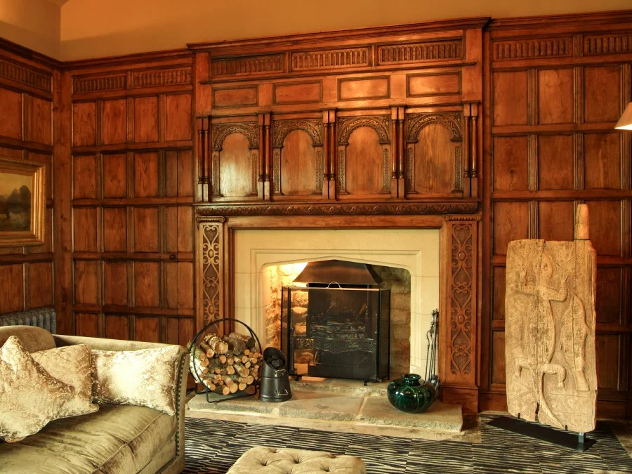 Oak-panelled wall of the Great Hall with a panelled overmantel above the fireplace
