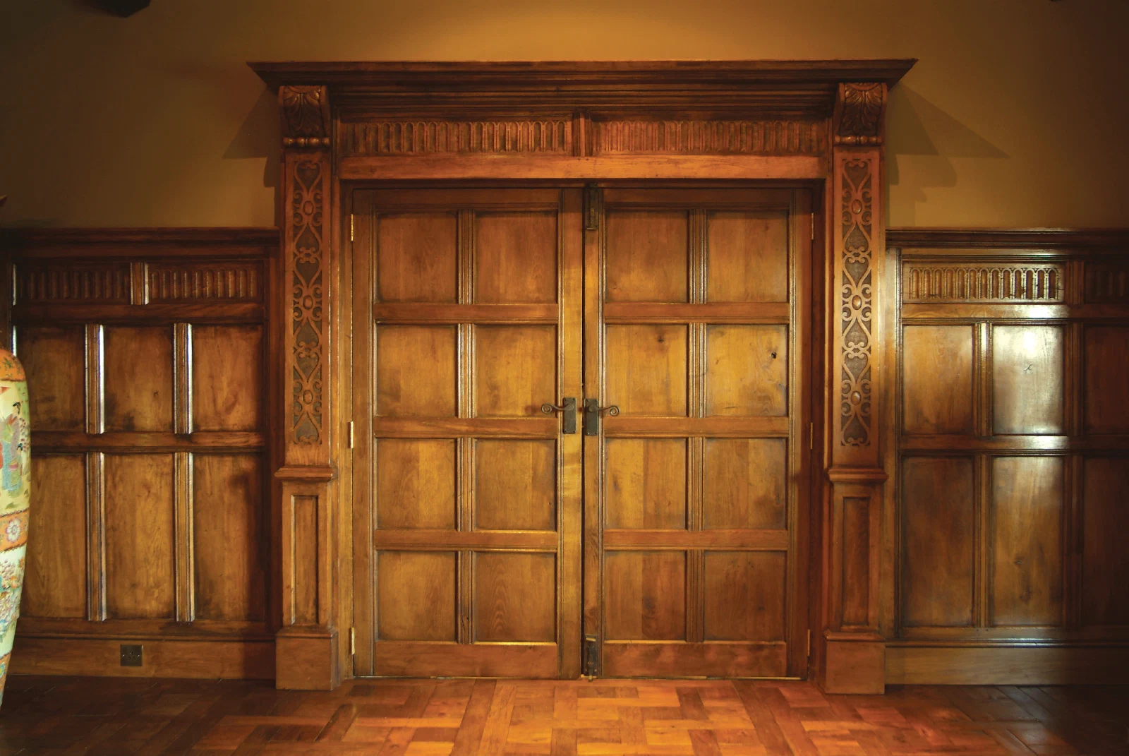 Oak double doors, carved surround and adjoining panelling at North Denton Farm