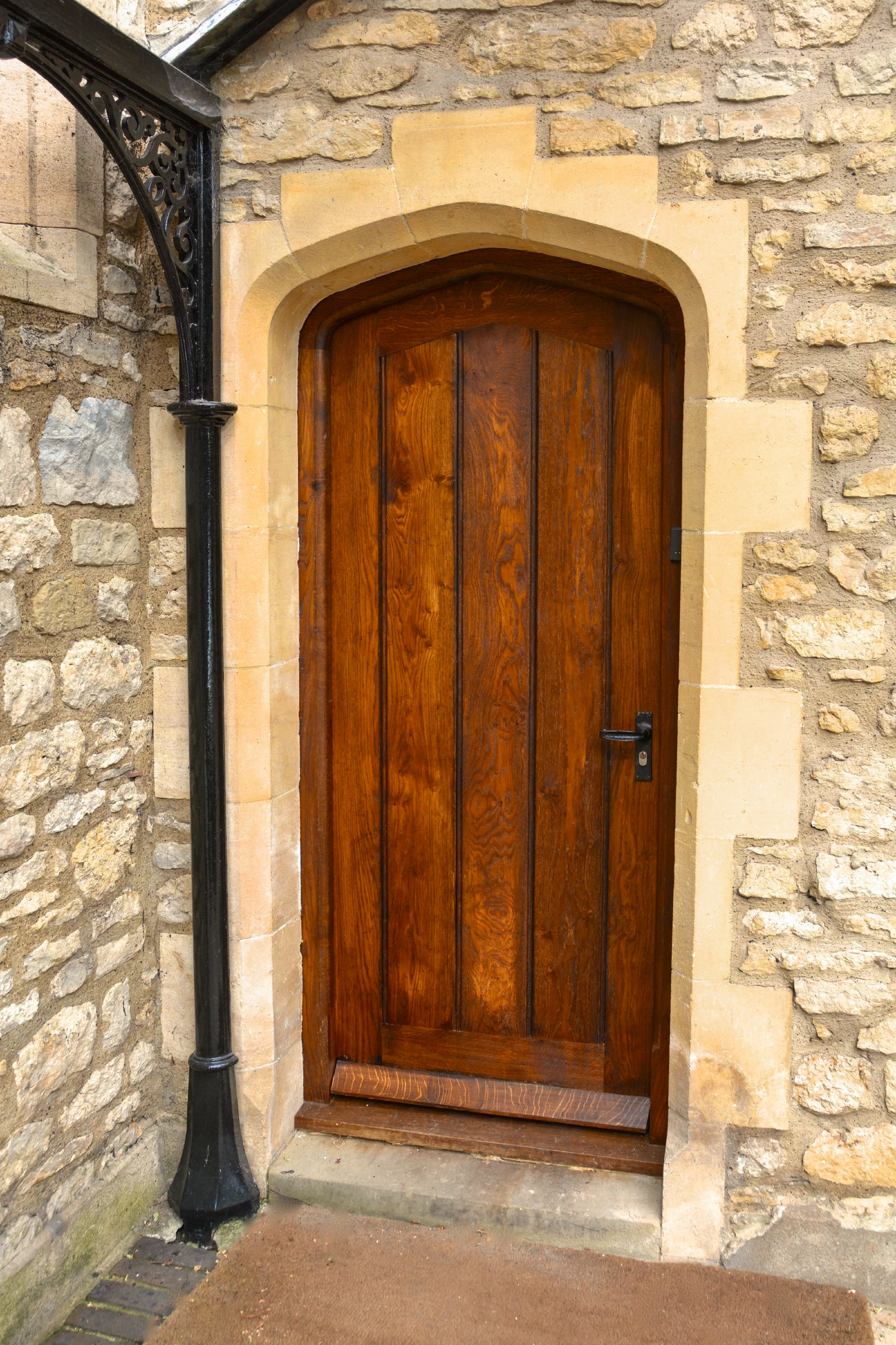 Arched oak plank door set within a stone opening