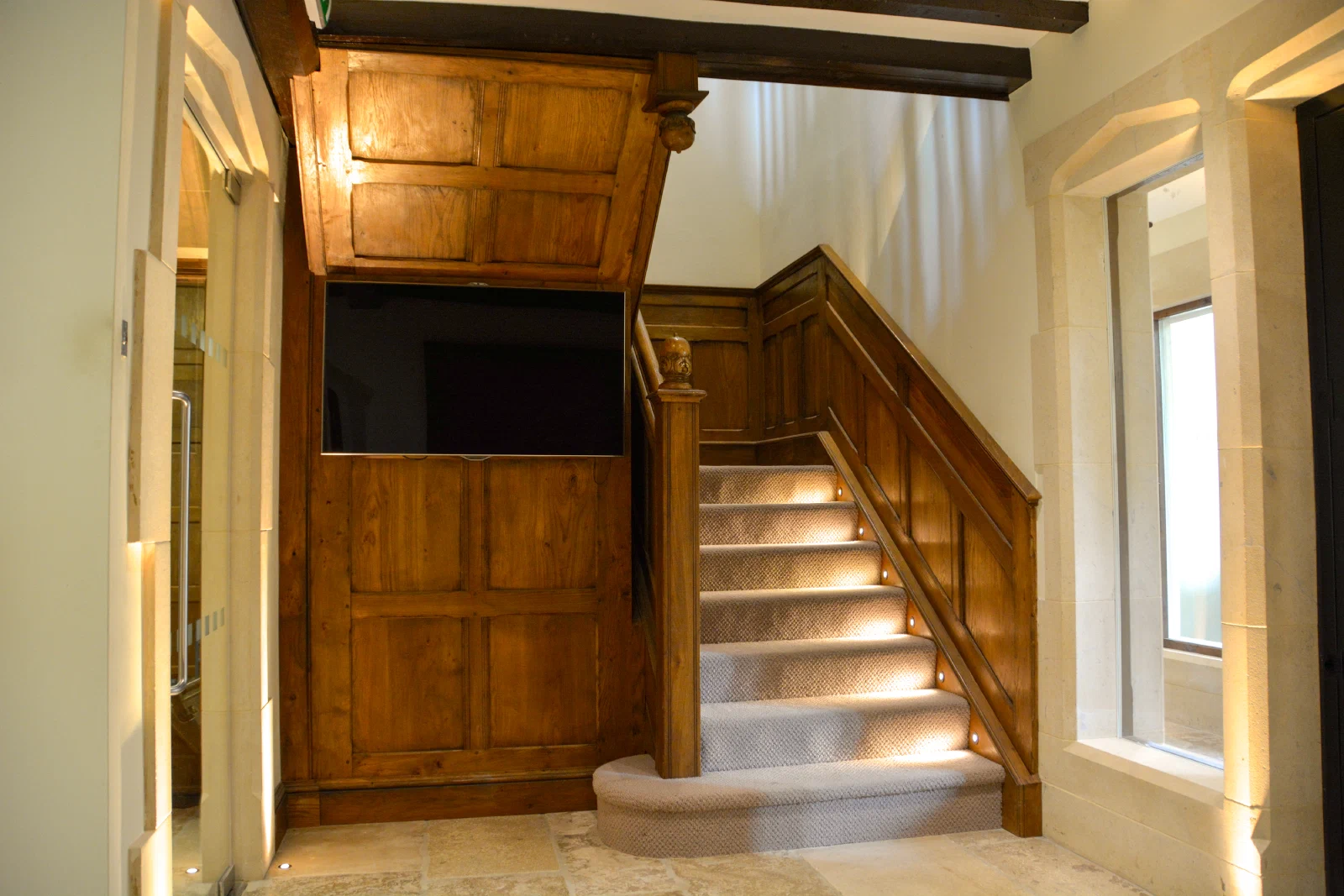 Oak-clad staircase rising through three floors