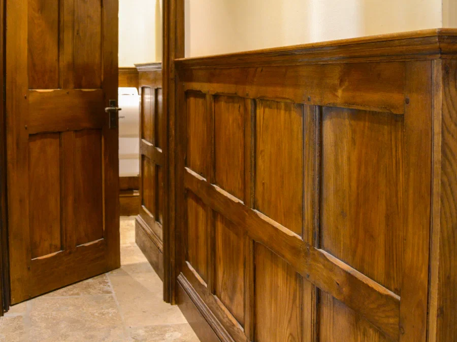 Panelled oak door and dado panelling along a corridor