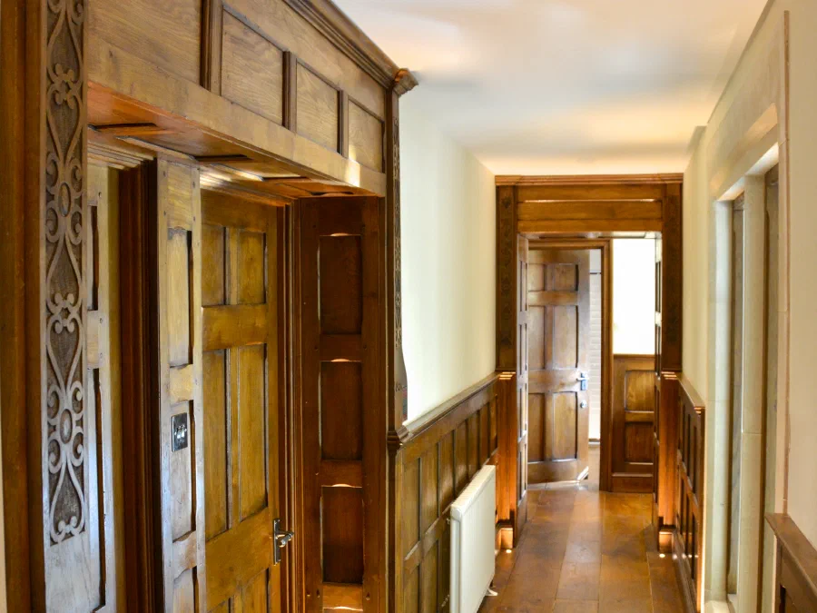 Oak-panelled corridor leading to a panelled door