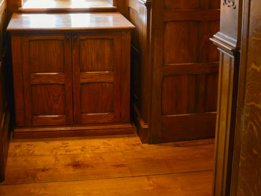Panelled oak door within dado panelling beneath an arched window