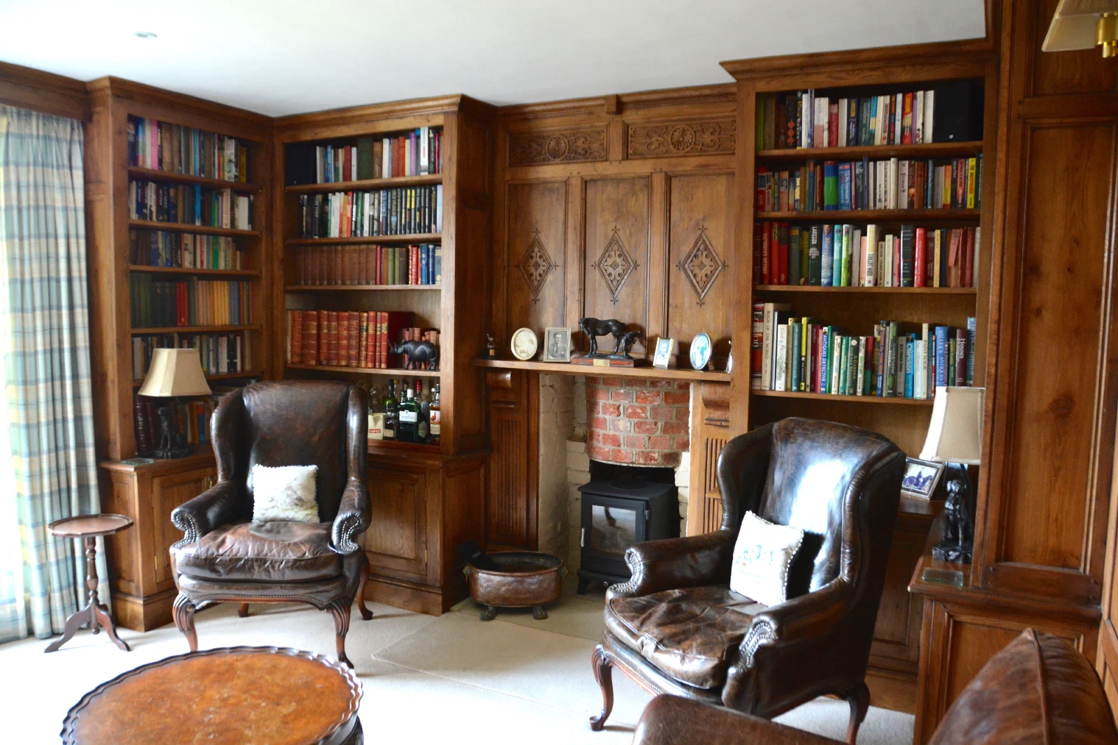 Oak study with fitted bookcases either side of a carved overmantel