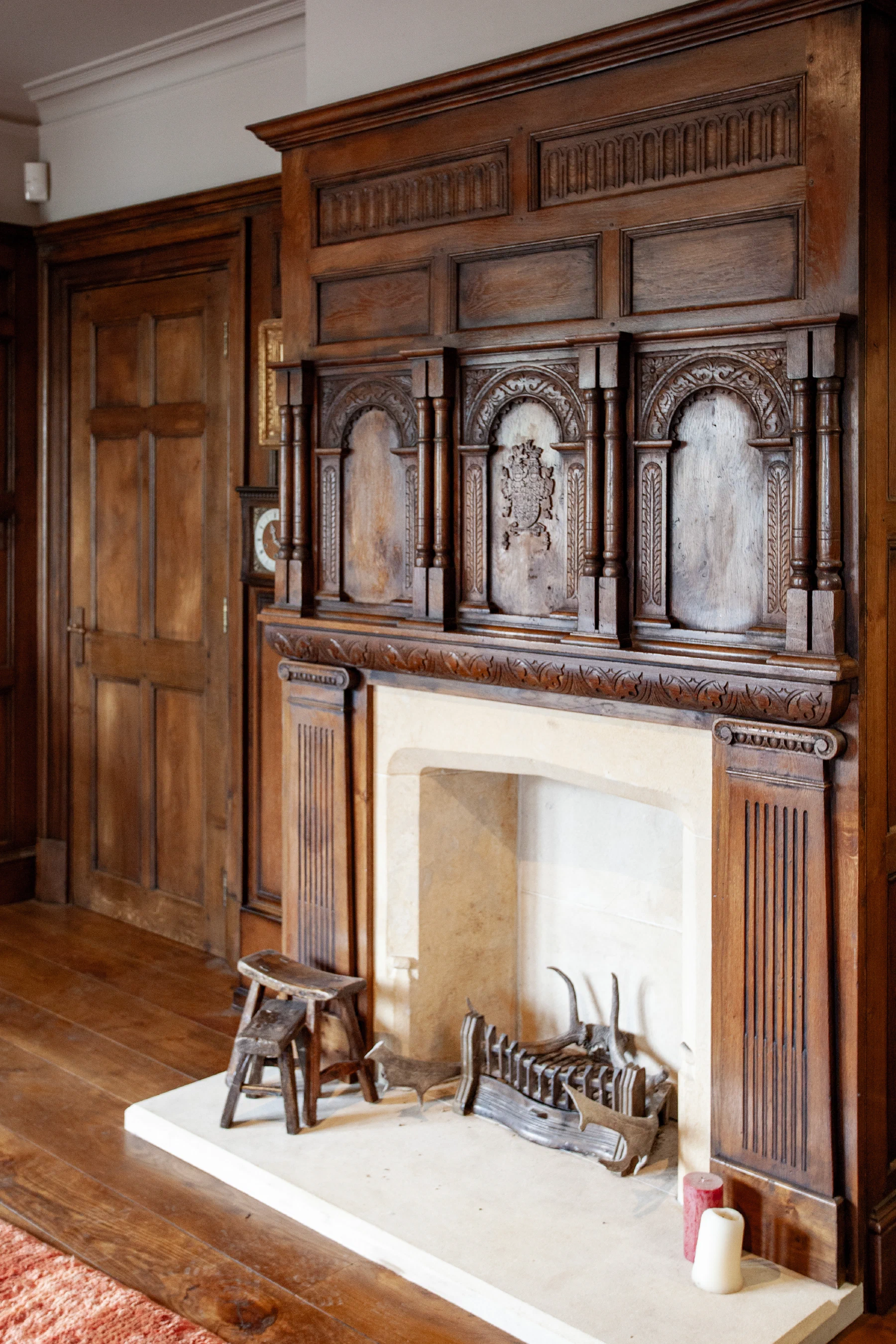 Fireplace and carved overmantel framed by the oak panelling