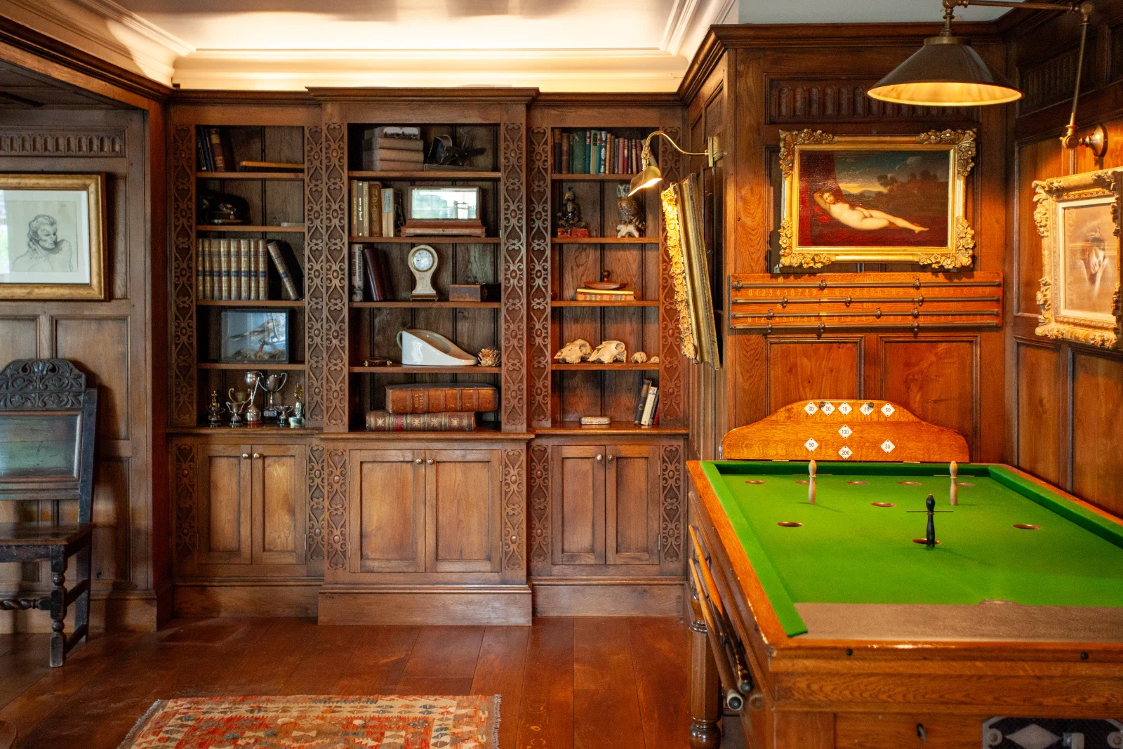 Fitted oak bookcases set into the panelling of the games room