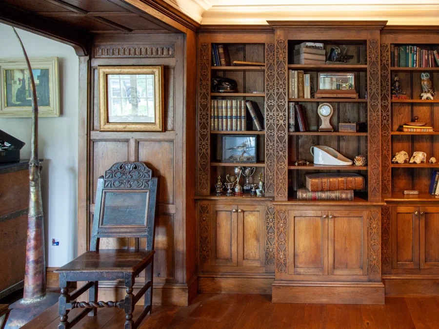 Fitted oak bookcase with hand-carved uprights and frieze detail
