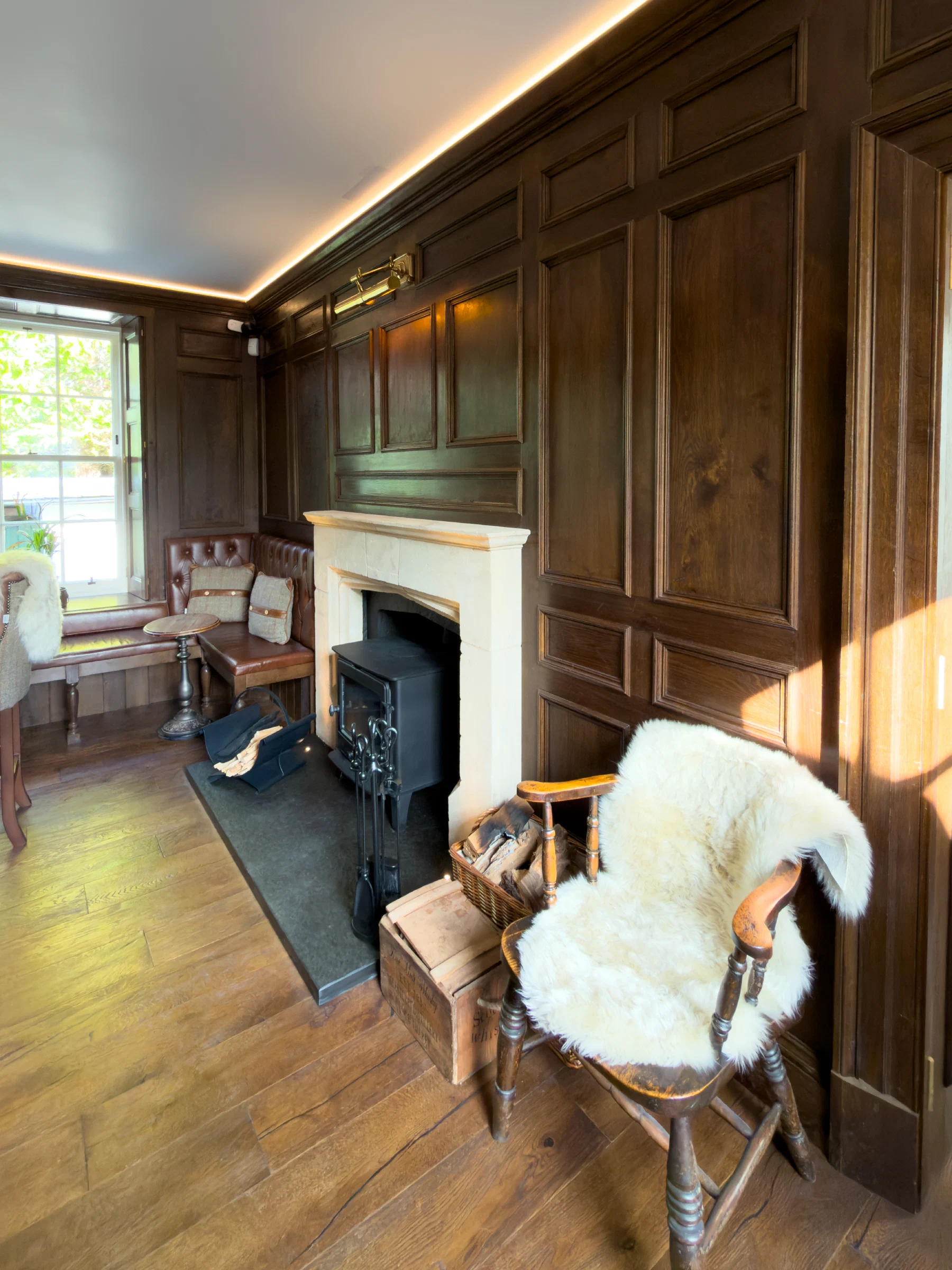 Fireplace corner with oak panelling and an armchair