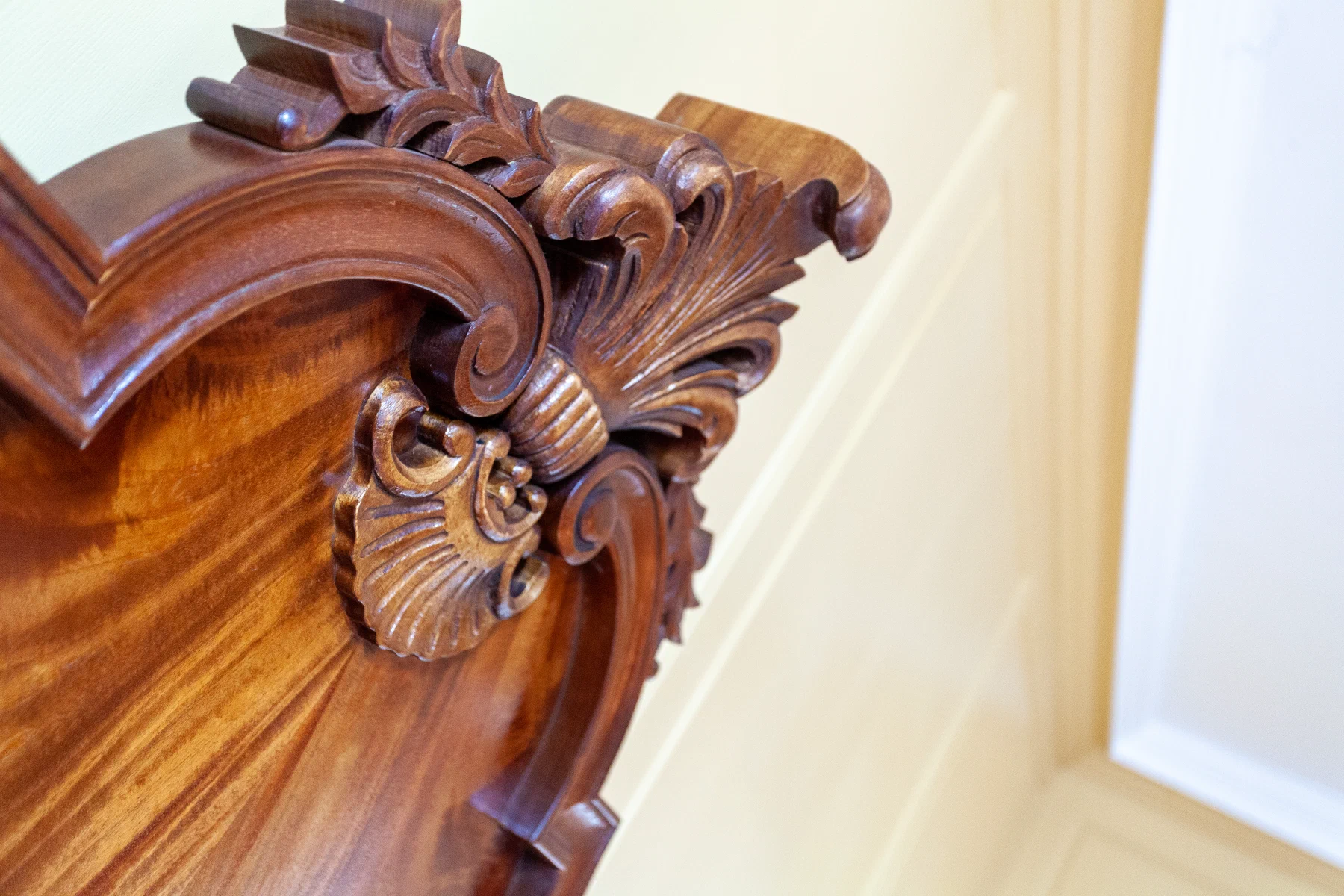 Carved mahogany headboard against the restored pine panelling