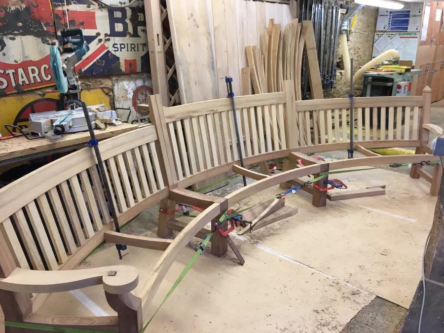 Curved garden bench being assembled and clamped in the workshop