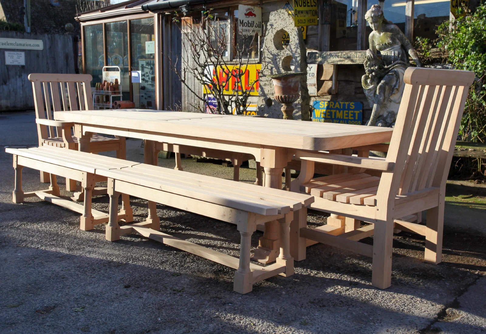 Long garden dining table with matching benches and armchairs
