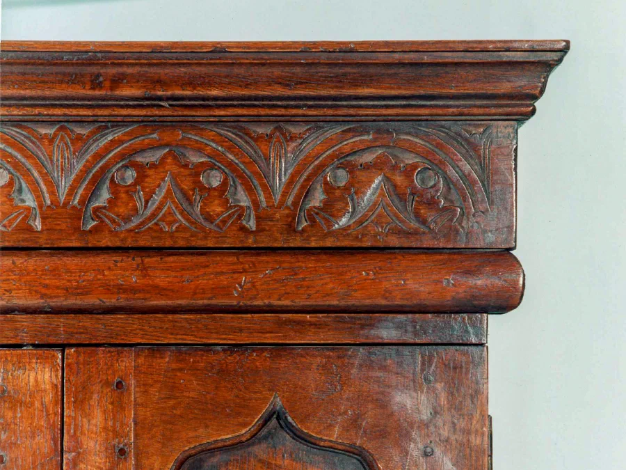 Close view of a carved frieze on an oak cupboard