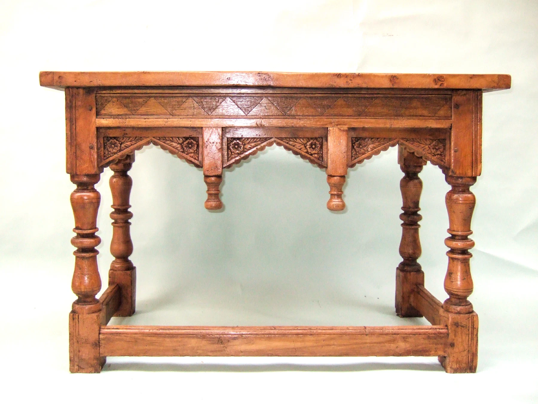 Oak side table with turned legs and a carved frieze
