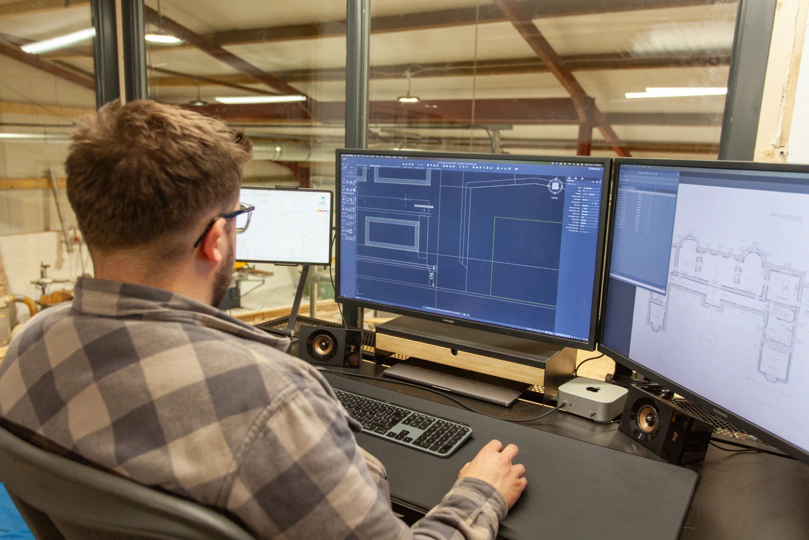 Designer developing architectural joinery drawings beside a building plan
