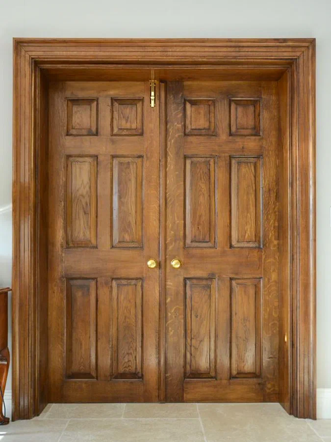 Pair of six-panelled timber doors with a broad moulded surround