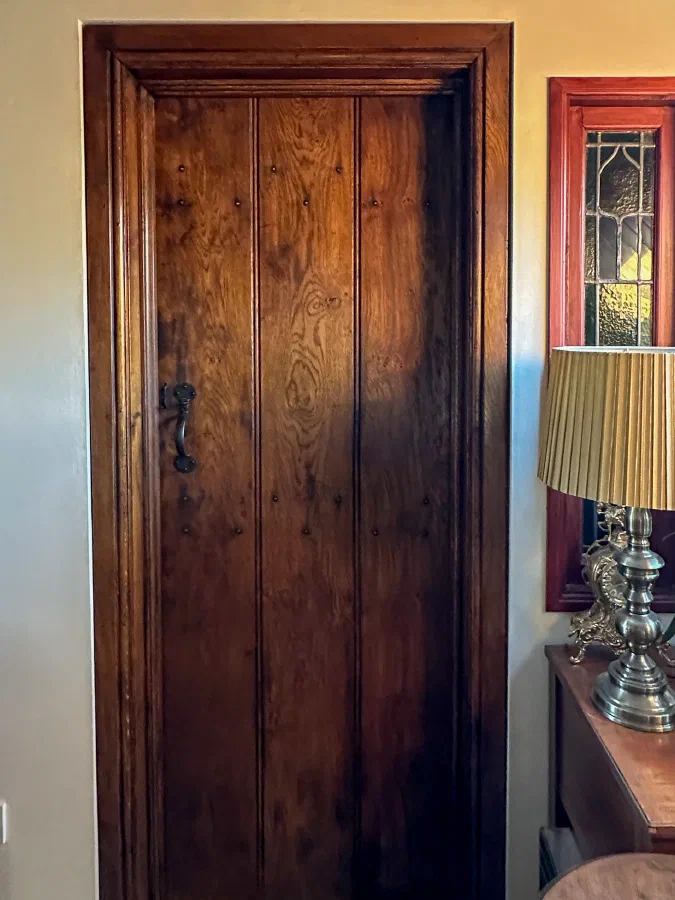 Internal oak plank door with a moulded timber surround beside a glazed panel