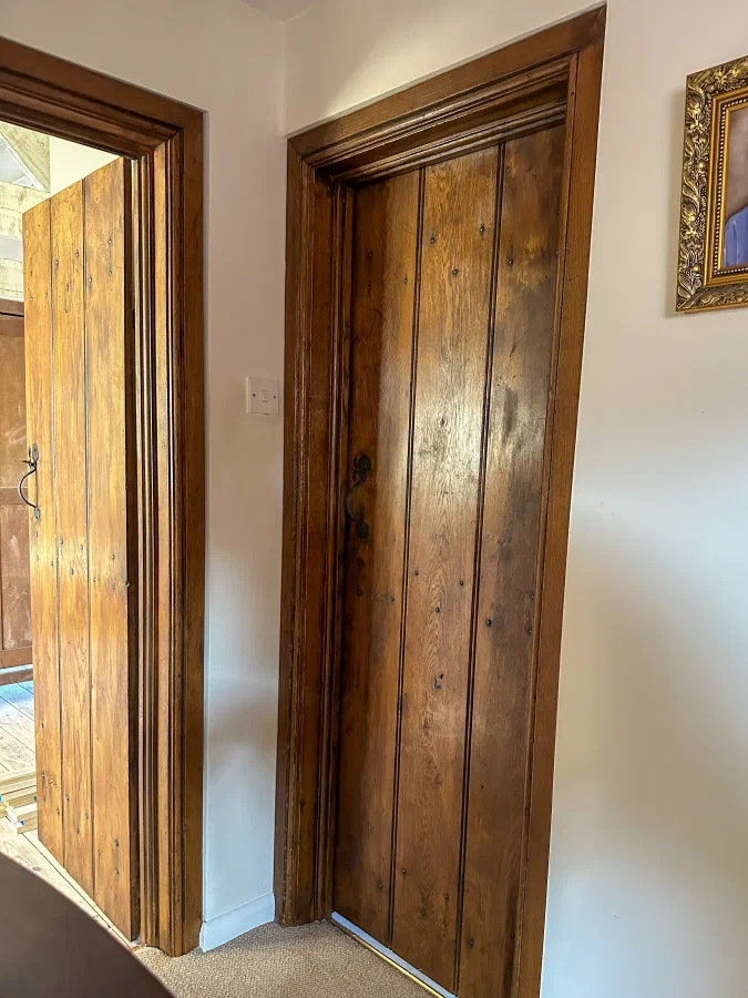 Two internal oak plank doors with moulded surrounds on a landing